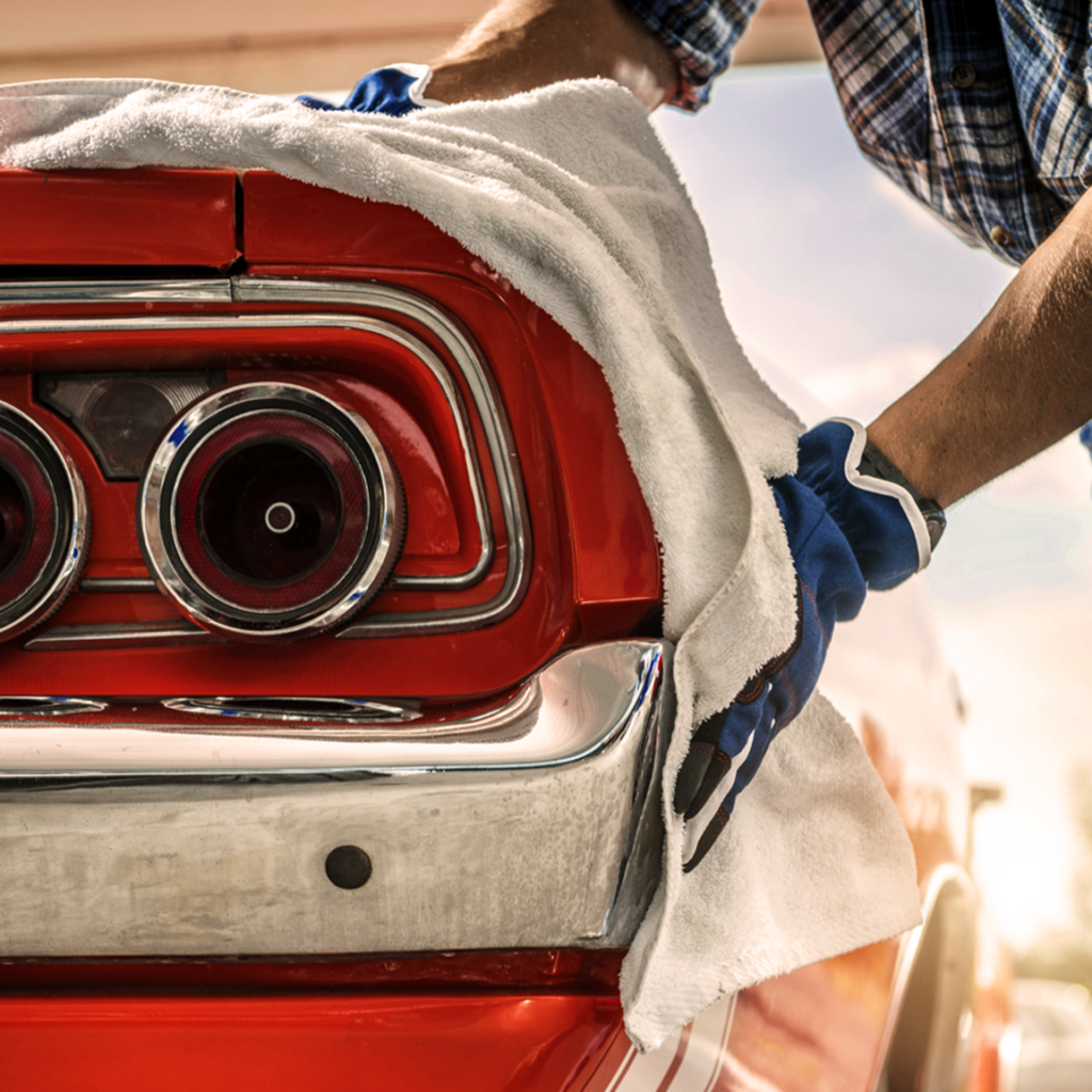 Classic car being cleaned with a soft cloth.