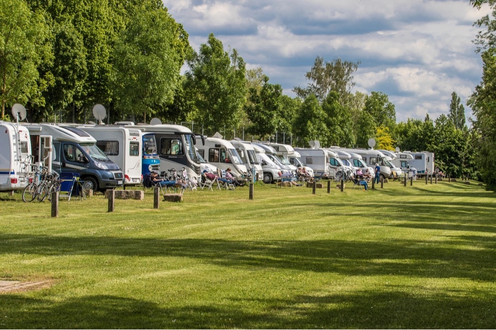 Row of RVs parked in an open field for an RV rally