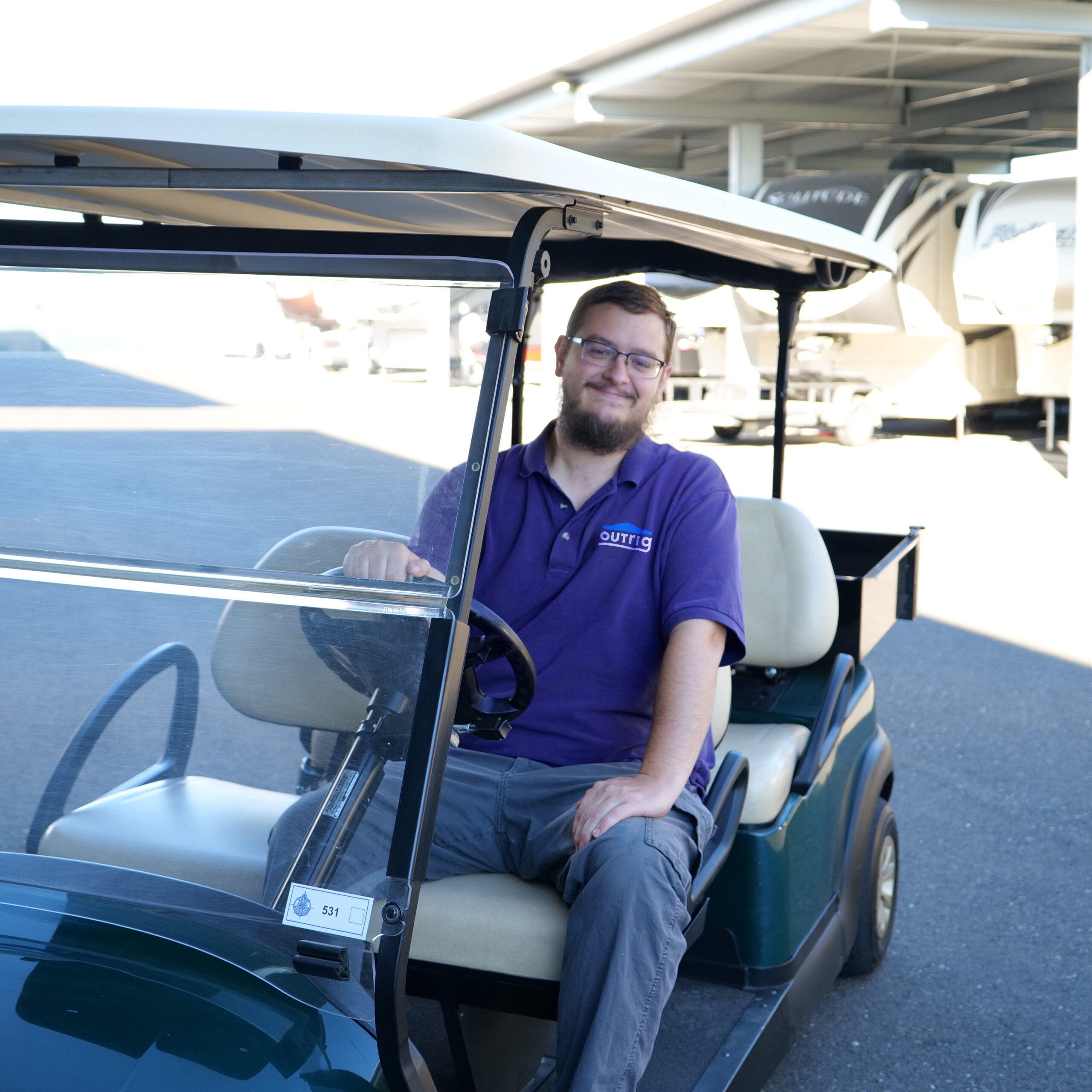 Property manager driving a golf cart at a storage facility.