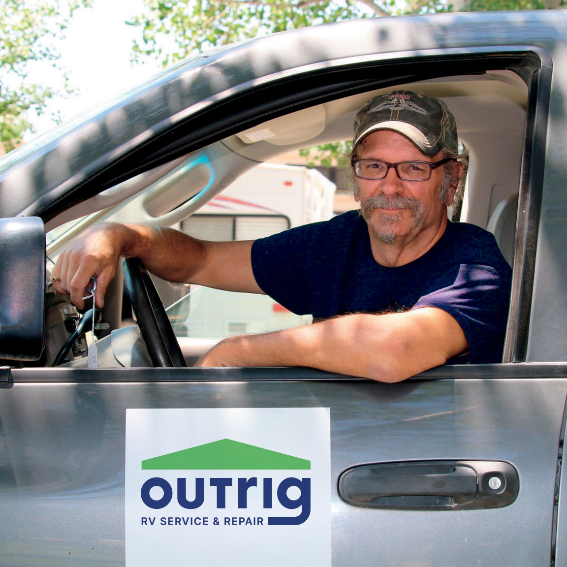 RV technician leaning out of a car with the Outrig logo on its door.